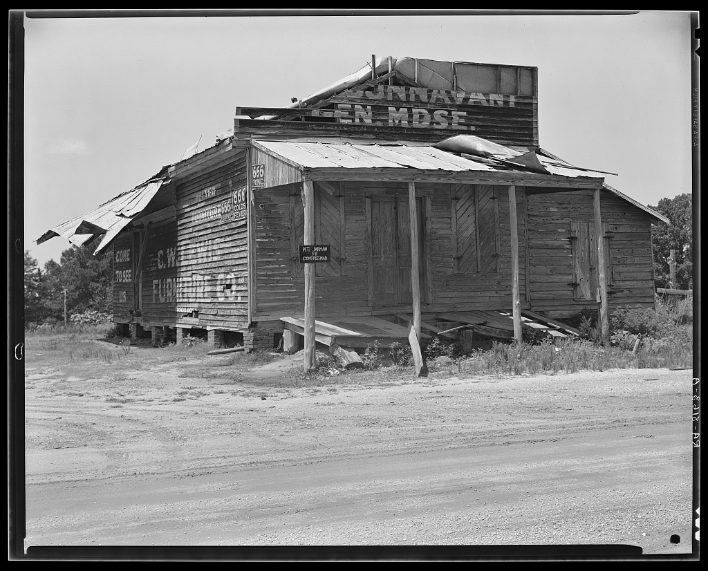 an abandoned store on the main road, advance, alabama — shelves empty, storefront dark